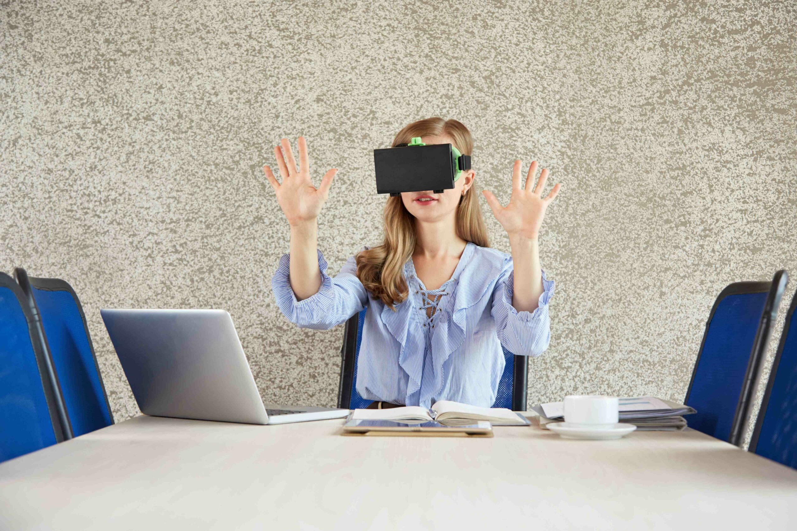 waist-up-shot-woman-wearing-vr-headset-gesturing-office-desk
